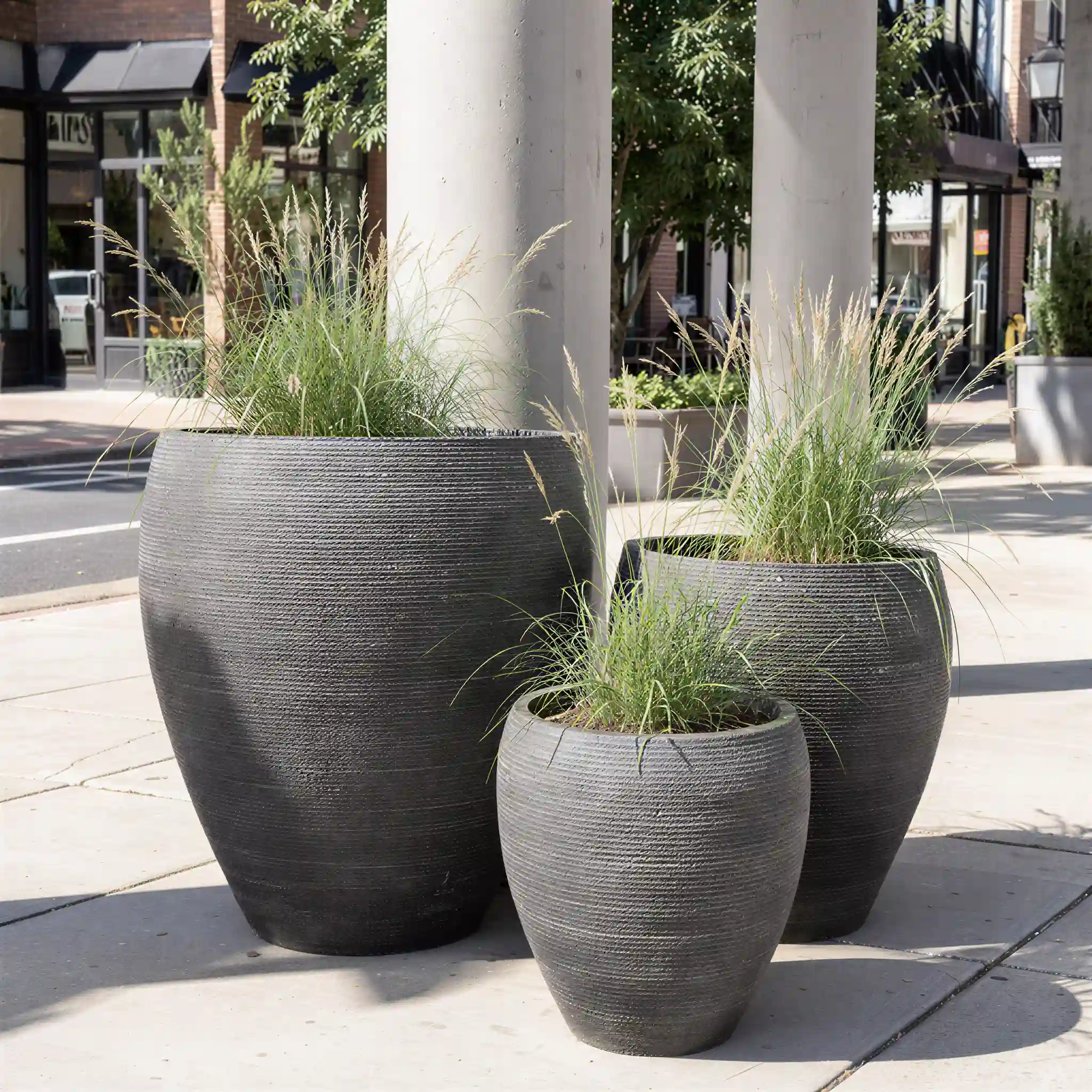 RCW-4011 ribbed round GFRC plant pots displayed in graduated sizes in a commercial plaza